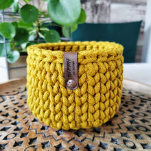 Lade das Bild in den Galerie-Viewer, Häkelkörbchen aus Bobbiny Garn in Spicy Yellow auf einem Holzteller.